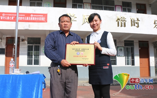 广西炭火行动助学志愿者协会代表向那亮小学活动点授牌。仲纪松 供图