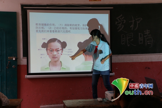 图为大化县志愿者为孩子讲做眼睛保健操知识