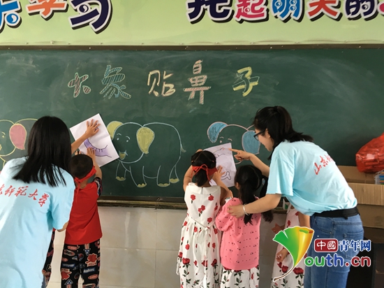 山东师大研支团成员组织学生开展给大象贴鼻子游戏.
