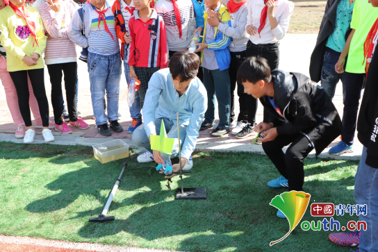 图为哈尔滨工程大学研支团成员李长浩为学生们试射水火箭。徐浩淞 供图