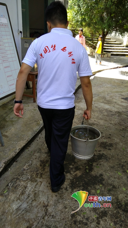 公安大学研支团成员李徐铭正在给阁楼小学的孩子们打水。李徐铭 供图