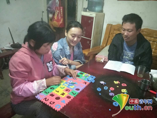 江西农业大学研支团队员与特殊孩子玩益智游戏。江西农业大学研支团 供图
