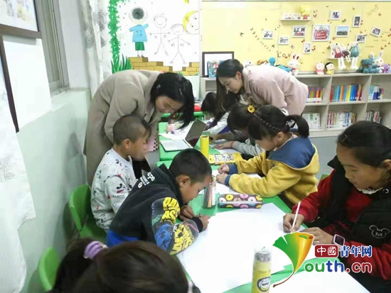 西安美术学院研支团成员指导朱村小学留守儿童进行绘画。西安美术学院研支团 供稿