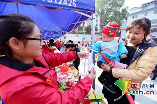 图为龙胜县志愿者为小朋友送上折纸工艺品。龙胜县团委 供图