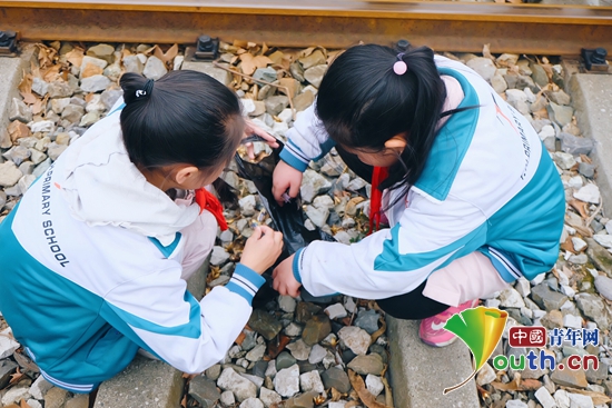 图为永和镇小学学生在清理铁路上的垃圾。浙