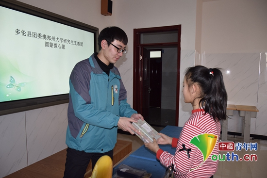 图为郑州大学研支团成员为学生发放爱心礼物。 高德培 供图 图为郑州大学研支团成员为学生发放爱心礼物。 高德培 供图