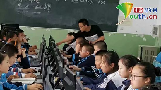 志愿者邰强为北屯中学学生上计算机课。河南牧业经济学院团委 供图